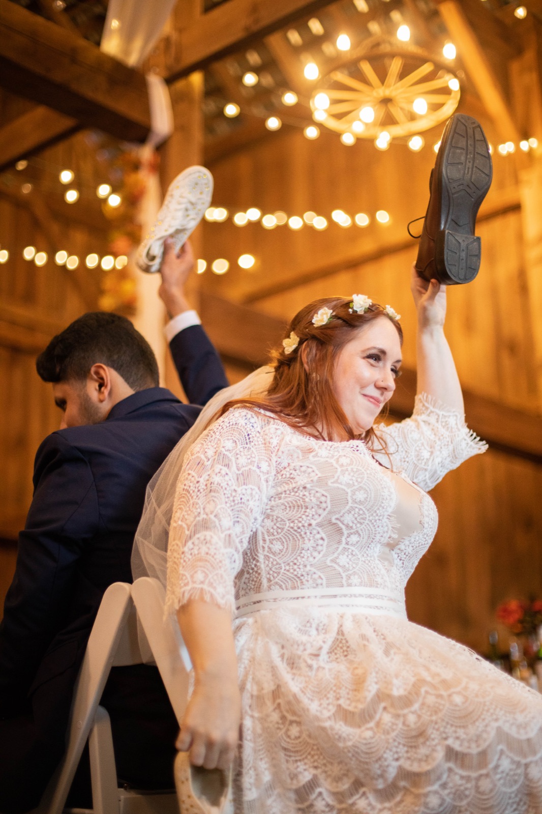 Father of the bride toasts while the couple sits at the head table in a barn