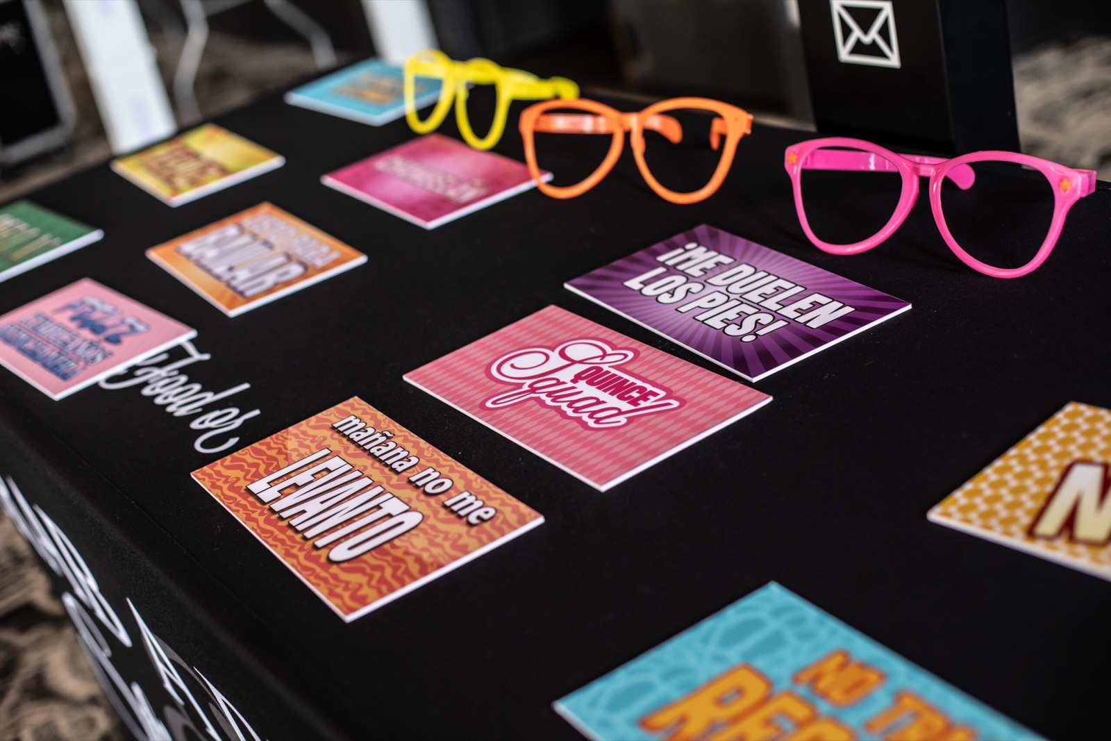 Spanish-language photo booth sign props and oversized neon glasses at The Reed
