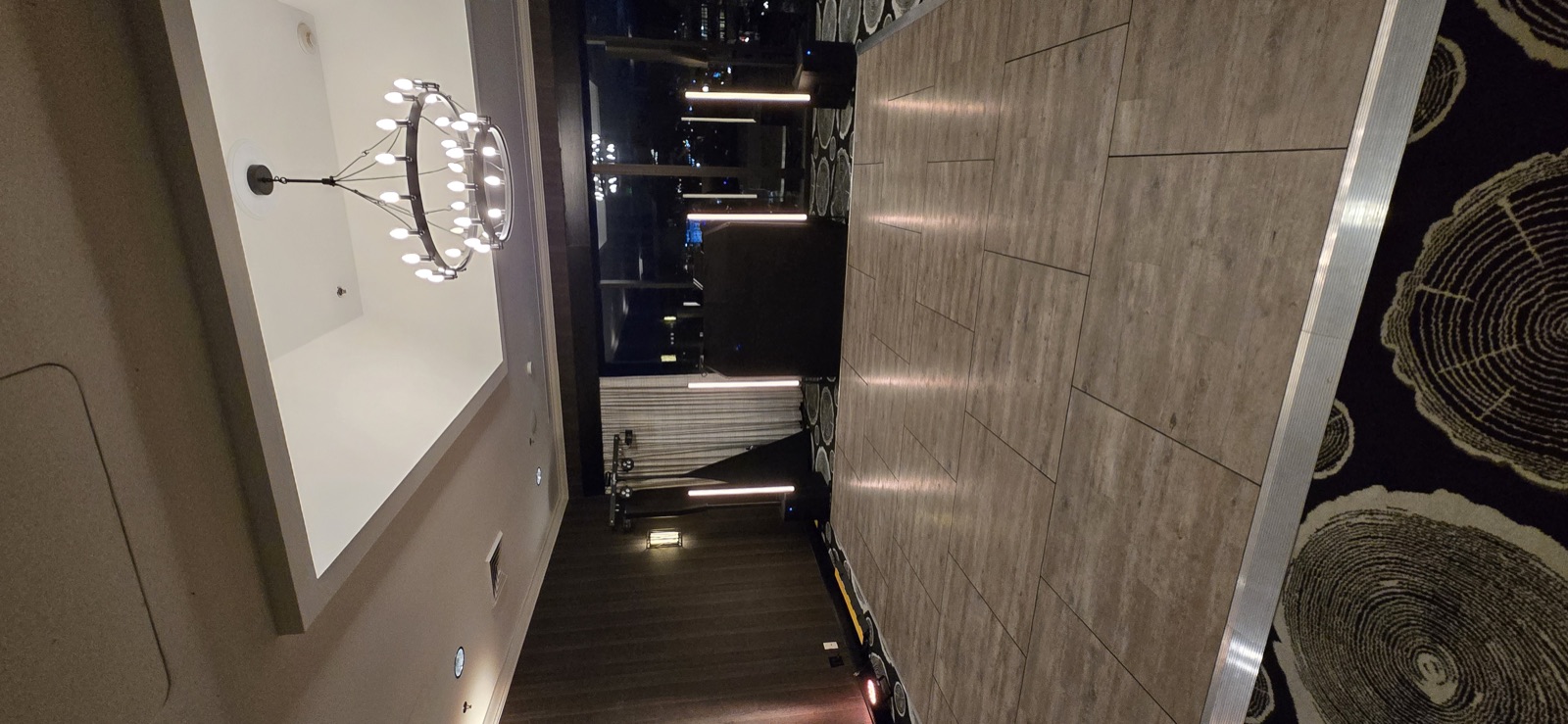 Empty portable dance floor with a black DJ booth, vertical light columns, and a chandelier in a hotel event room