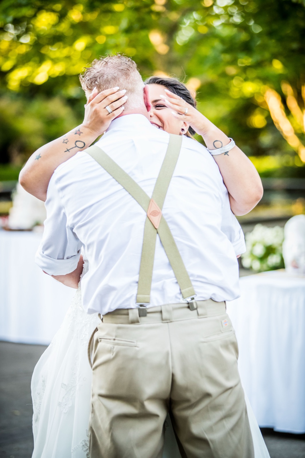Bride hugging the groom from behind during their first dance at the Oregon Garden