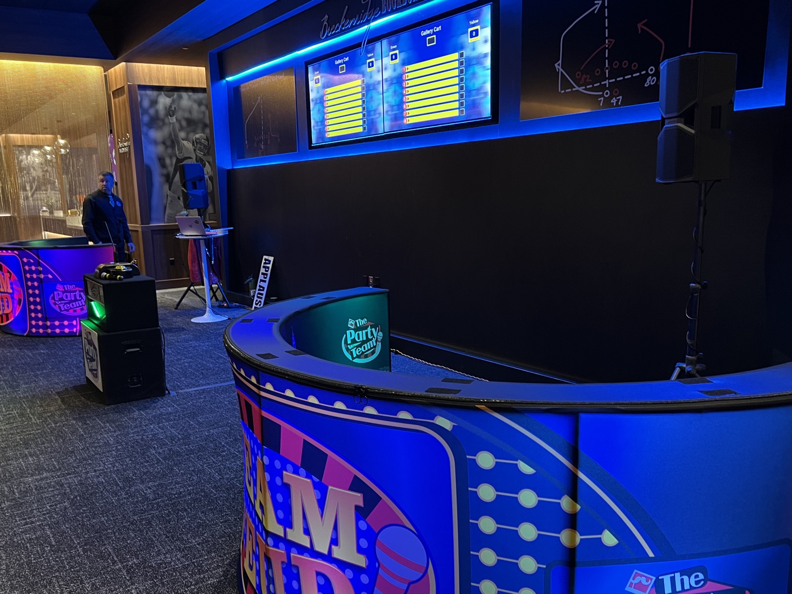 Team Feud stage with strike graphic on twin screens and host podium with timer at a Salem corporate event