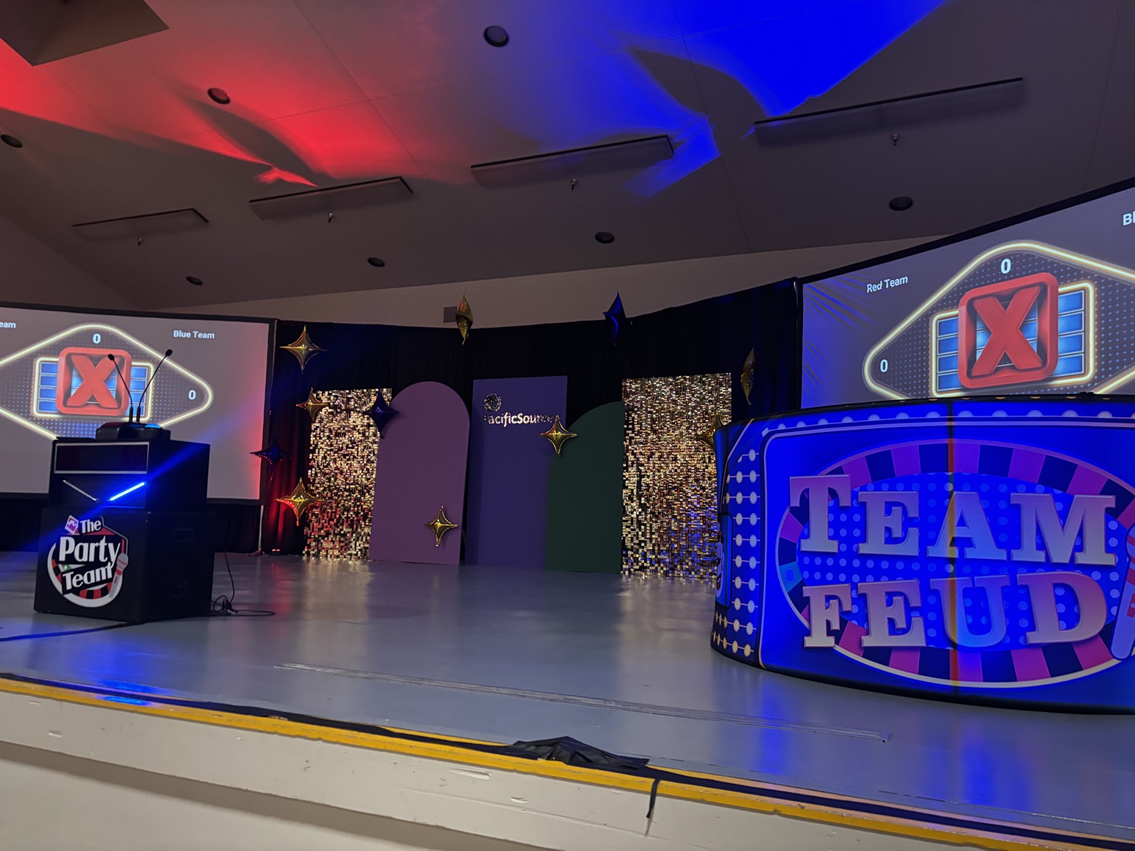 Team Feud game show stage in Salem with LED podium, dual scoreboards, Party Team host stand, and gold sequin backdrops at a PacificSource event