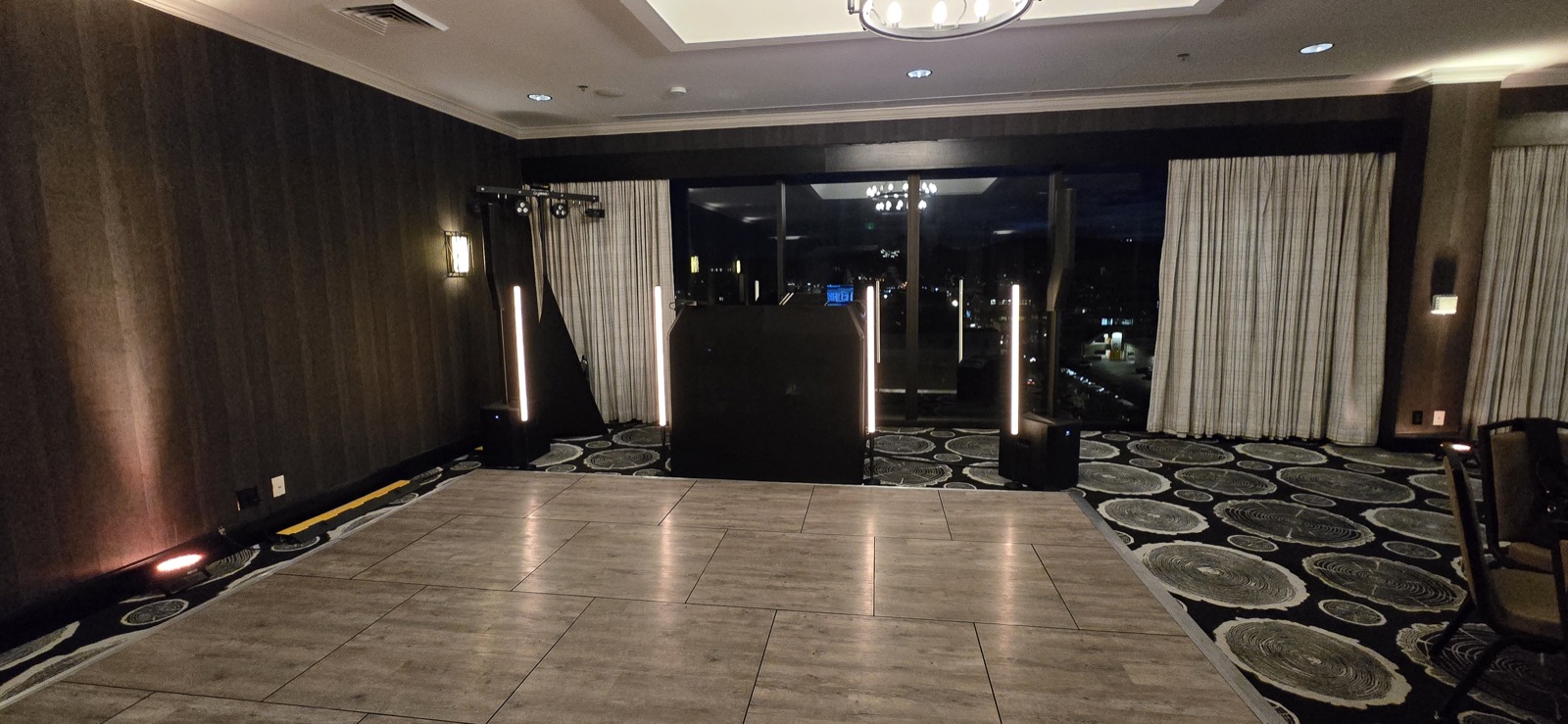 DJ booth flanked by lit light columns beside an empty portable dance floor at The Graduate in Eugene