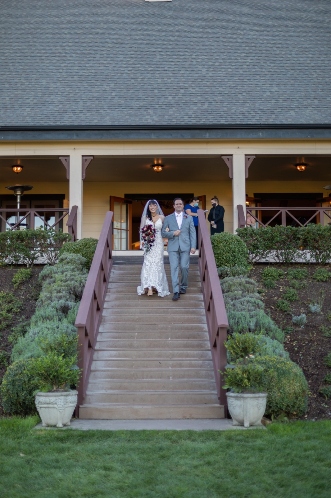 Bride and groom walk arm in arm down outdoor stairs at Zenith Vineyard near Salem, Oregon