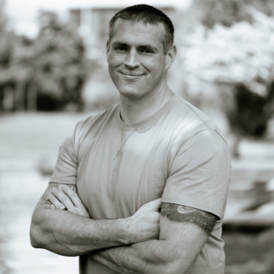 Zach Thomas, arms crossed, smiling in a black-and-white outdoor portrait