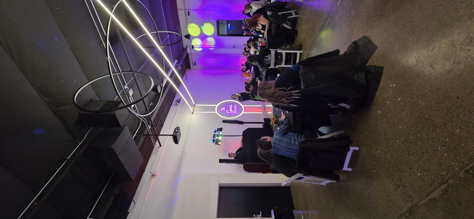 DJ with purple uplighting while guests sit at tables at The Space in Salem